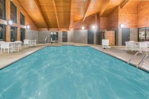 Kasson的住宿－Baymont by Wyndham Kasson Rochester Area，一座大型游泳池,位于一座拥有木制天花板的建筑中