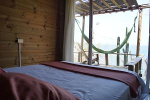 a bed in a room with a window at Hotel Cactus Taganga in Taganga