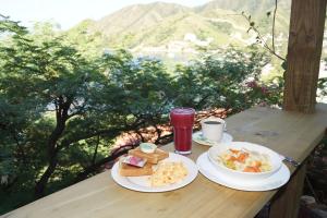 two plates of food on a wooden table with a view at Hotel Cactus Taganga in Taganga