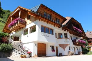 une maison fleurie dans les montagnes dans l'établissement Appartamenti Ciasa Linda, à San Martino in Badia