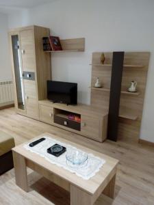 ein Wohnzimmer mit einem TV und einem Couchtisch in der Unterkunft Alojamiento Samumari in Ciudad-Rodrigo