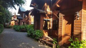 una casa de madera con un banco delante en Cabañas Orillas del Lago, en Pucón