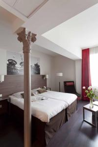 A bed or beds in a room at City Lofthotel Saint-Etienne