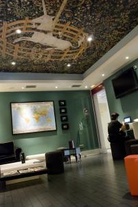 a man standing in a lobby with a map on the wall at Albergue Revolutum Hostel in Salamanca