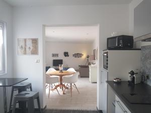 a kitchen and dining room with a table and a table and chairs at "Ô Tour's Angels" FEBVOTTE in Tours