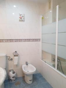 a bathroom with a toilet and a tub and a sink at La Explanada in Alicante