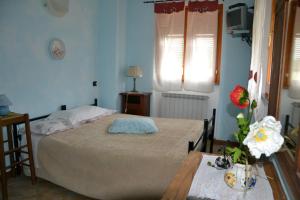 a bedroom with a bed and a table with flowers on it at Agriturismo LA TAVERNA DEL NONNO in Borzonasca +33 photos