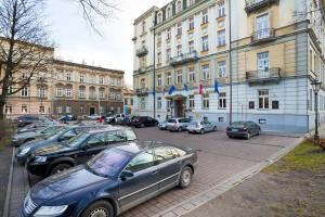 un grupo de coches estacionados frente a un edificio en Hotel Royal, en Cracovia