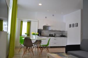 a living room with a table and green chairs at Apartamenty Pod Rudką Czarna Góra Agroturystyka in Sienna