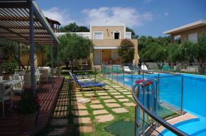 a pool with chairs and a house and a building at Elea in Kato Daratso +49 photos