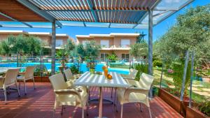 a patio with a table and chairs and a swimming pool at Elea in Kato Daratso