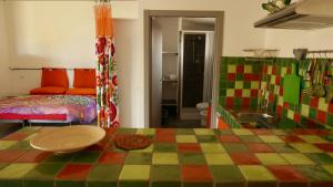 Habitación colorida con cama y mesa. en Naramanue, en Dorgali