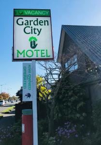 a sign for a garden city motel on a street at Garden City Motel in Christchurch