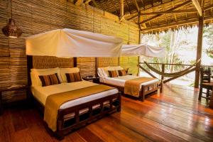 Tempat tidur dalam kamar di Refugio Amazonas Lodge