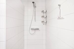 ヴィンターベルクにあるKristall Apartmentsの白いタイル張りのバスルーム(シャワー付)