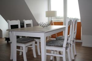 uma mesa de jantar branca com cadeiras brancas em Kiekut em Baabe