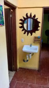 baño con lavabo y espejo en la pared en La Casa de Rolando, en Puerto Viejo