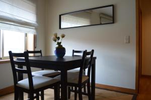 ポルトにあるLife in Porto Apartment by JCの黒いテーブルと椅子、花瓶