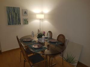 a dining room table with four chairs and a lamp at Liberdadeflat4u in Braga