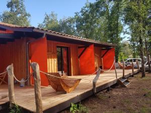 a house with a hammock on a deck at Au Bois Flotté in Hourtin