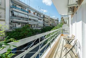 einen Balkon mit 2 Stühlen und Gebäuden in der Unterkunft Style 'n' Comfort in Thessaloniki