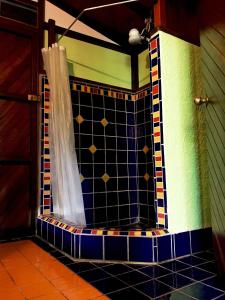 a tiled shower in a room with a curtain at Casita Rolando in Puerto Viejo