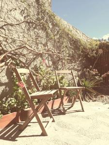 two wooden chairs sitting on top of a beach at De Luna in Puerto Pirámides