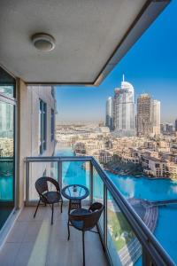 a balcony with chairs and a table and a view of the city at One Bedroom Apartment Dubai Fountain & Old Town View by Auberge in Dubai