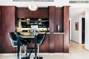 a kitchen with wooden walls and a table and chairs at One Bedroom Apartment Dubai Fountain & Old Town View by Auberge in Dubai