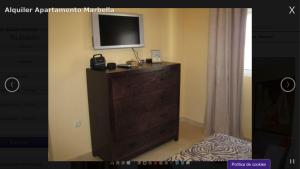 une télévision au-dessus d'une commode dans une pièce dans l'établissement Apartamento Marbella Playa, à Marbella