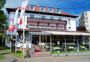 ein Hotel mit Flaggen vor einem Gebäude in der Unterkunft Hotel Restaurant Thum in Balingen