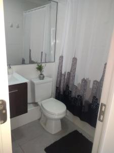 a bathroom with a toilet and a sink at Departamento arica in Arica +8 photos