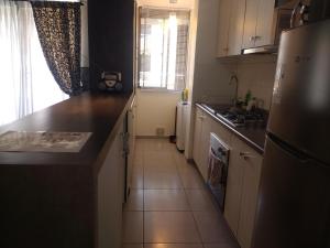 a kitchen with white cabinets and a counter top at Departamento arica in Arica