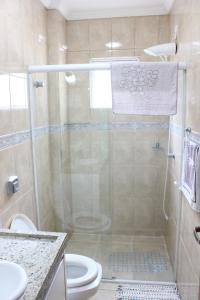 een badkamer met een douche en een toilet bij Apartamento em Meia Praia in Meia Praia