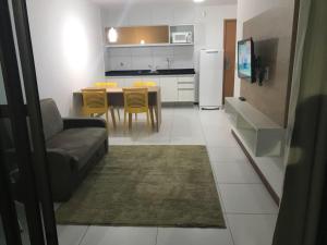 a living room and kitchen with a couch and a table at Residence Iloa Resort in Barra de São Miguel