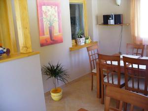 a dining room with a table and a potted plant at Fehér Ló Fogadó in Bük