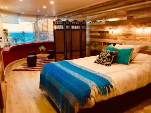 1 dormitorio con 1 cama grande con manta azul en Apartamento Mirador, en Viña del Mar