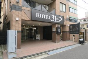 ein Hotelschild an einem Gebäude auf einer Straße in der Unterkunft HOTEL 31 in Funabashi