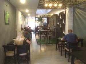 a group of people sitting at tables in a restaurant at Kha Hostel in Hue