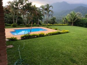 a swimming pool in a yard next to a lawn at Casa em penedo in Penedo