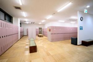 a large room with pink lockers and a bench at Sakudaira Plaza 21 in Saku