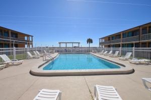 a swimming pool with lounge chairs and a trampoline at Buccaneer Inn in St. George Island