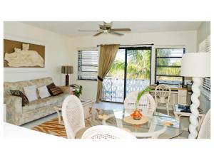 ein Wohnzimmer mit einem Sofa, einem Tisch und Stühlen in der Unterkunft 8 Villa Martinique in Freeport