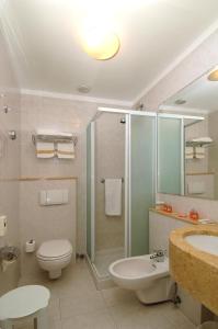 een badkamer met een toilet, een wastafel en een douche bij Hotel Piccolo Lido in Bordighera
