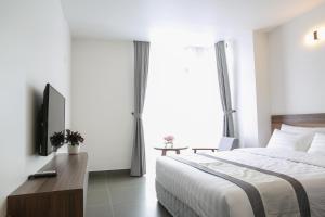 a hotel room with a bed and a television at Punt Hotel in Hai Phong