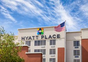 Ein Hyatt-Gebäude mit amerikanischer Flagge oben in der Unterkunft Hyatt Place Columbus-North in Columbus