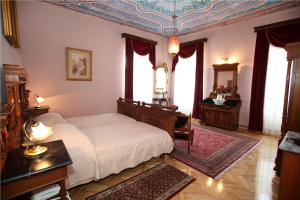 1 dormitorio con cama, mesa y ventanas en Villa Moretti, en Trogir