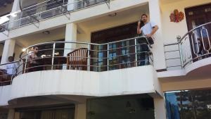 a man standing on a balcony talking on a cell phone at Vino Villa Tourists & Local Accommodations - 24 Hrs in Kandy