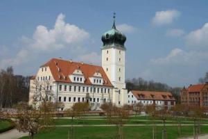 a large building with a clock tower on top of it at Hotel-Pension Grüne Linde in Delitzsch