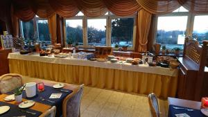 einen Tisch mit Essen in einem Zimmer mit Fenstern in der Unterkunft Hotel Odenwaldblick in Rödermark